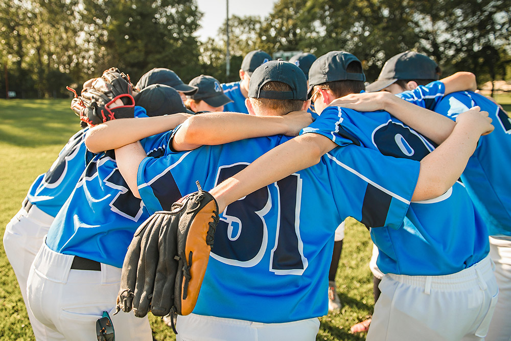 Group of baseball players in blue uniforms huddling