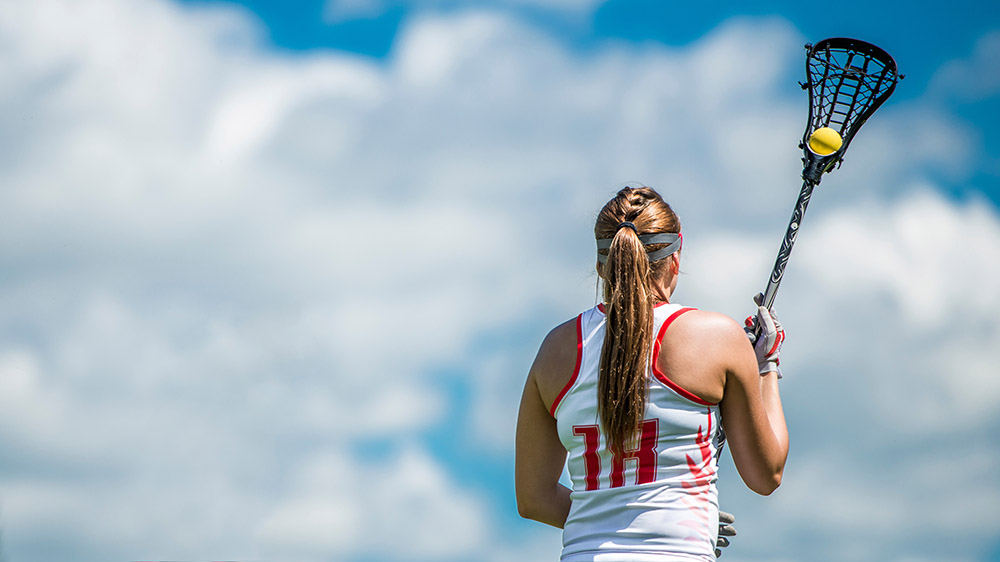 Female lacrosse player holding stick