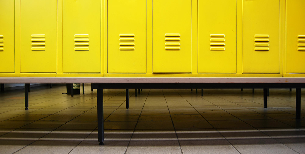 Yellow doors in a locker room and a bench